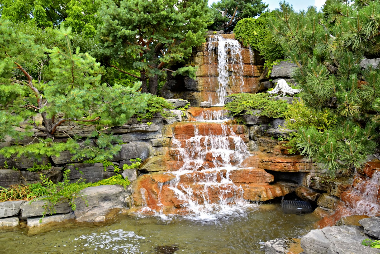 Garten mit Naturstein, Wasserlauf und üppigem Grün