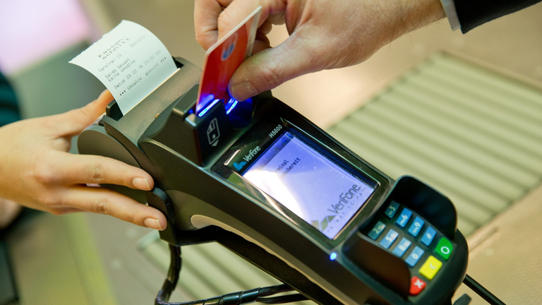 Kunde bezahlt mit EC-Karte an einem Kartenterminal.