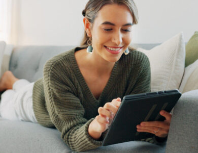 Frau liest auf dem Sofa auf einem eReader