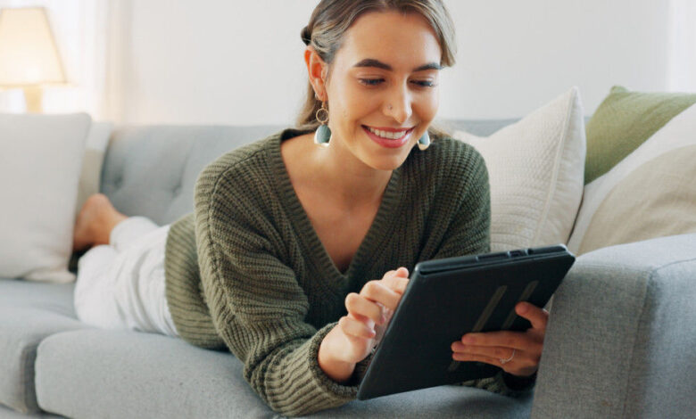 Frau liest auf dem Sofa auf einem eReader